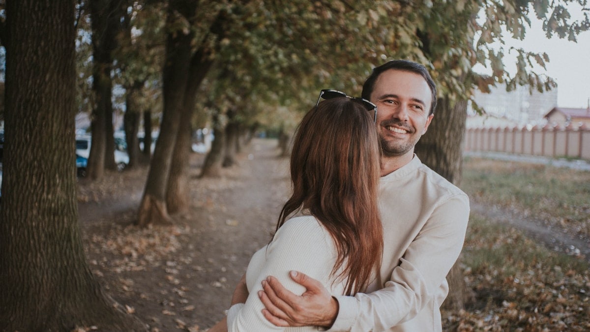 a man holding a woman in his arms in a park